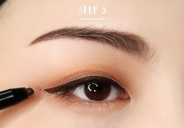 Step 3：用深棕色眼线笔沿着睫毛根部画一条眼线，眼尾上扬。